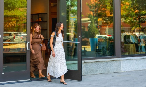 two women walking out of a building