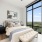 neighborhood views from floor-to-ceiling windows in bright bedroom