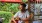 man with a drink sits at an outdoor bar