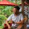 man with a drink sits at an outdoor bar