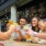 men and women with drinks around an outdoor table