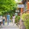 people walk along sidewalk with row of neighborhood shops