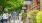 people walk along sidewalk with row of neighborhood shops