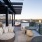 partially covered rooftop balcony with tables and chairs